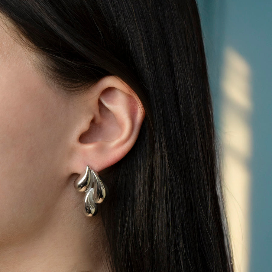 Model draagt minimalistische oorbellen zilver